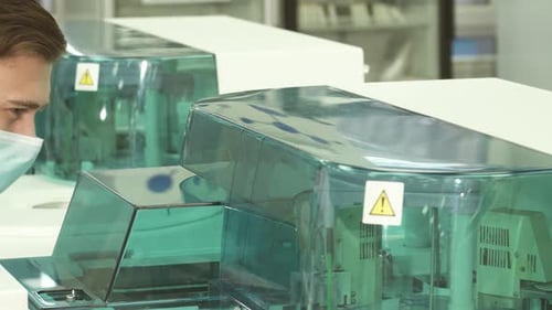 Scientist Examining Modern Laboratory Equipment in Clinic