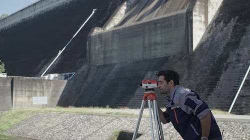 Blue collar worker is working at the dam.