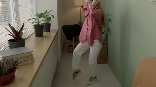 Woman with Headphones Dances Energetically at Home