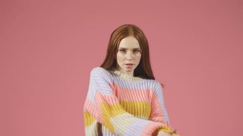 Redhaired Female Model Posing for the Camera on an Isolated Background in the Studio