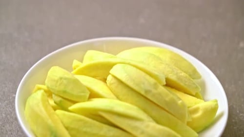 fresh green and golden mango sliced on plate