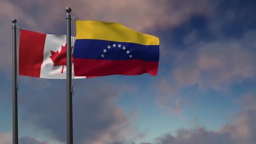 Waving Flags of Canada and Venezuela Against Cloudy Sky