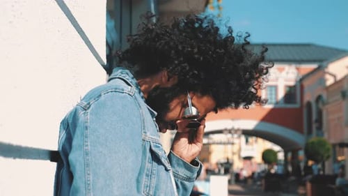 Stylish Man Putting on Sunglasses on Sunny Street