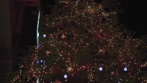 Close up of Christmas tree lights and decorations at night. Pedestal shot