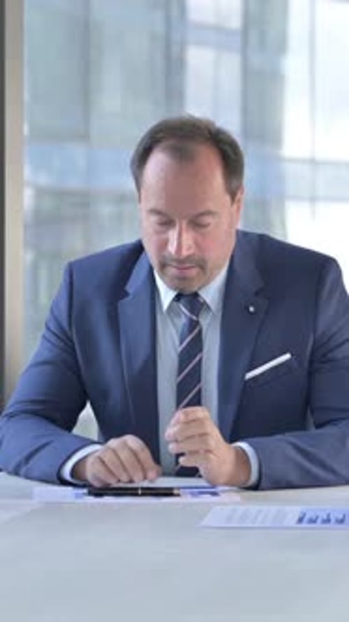Middle Aged Businessman having talk on Documents with Assistants on Office Table, vertical video