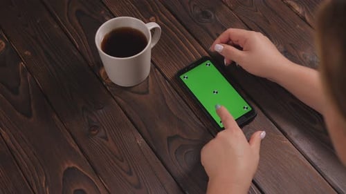 Closeup of a Woman Drinking Coffee and Using a Phone with a Green Screen