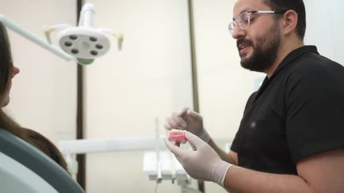 Dentist Explains Dentures to Patient in Clinic