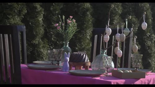 A table in the yard during spring for an Easter celebration lunch, decorated with Easter eggs