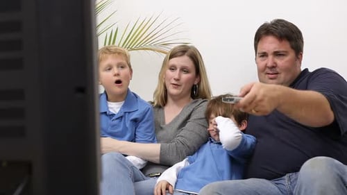 Family Relaxing on Sofa Watching Television Together