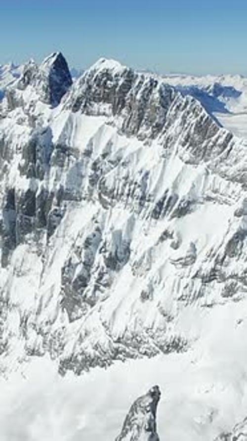 Experience the Stunning Aerial View of a Majestic Snowcapped Mountain Ranges Beauty