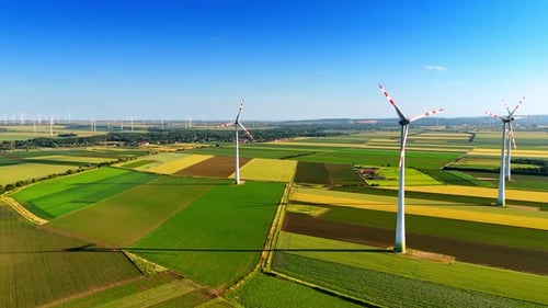 Aerial View of Wind Turbines in Green Fields