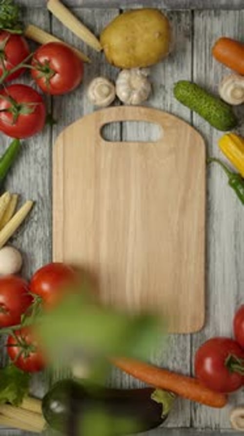 Vertical of Parsley Leaves Falling on a Cutting Board with Organic Vegetables Around