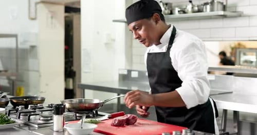 Chef, man and cooking meat with seasoning, pepper and catering process in restaurant kitchen