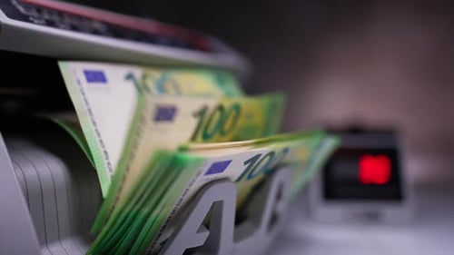 New green hundred euro banknotes being counted in cash machine. Money counting machine with bills