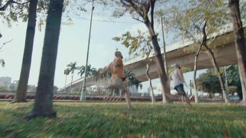 Two Parkour Athletes Performing Side Flips in the Park
