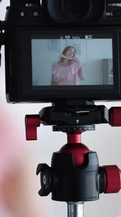Woman Presents Pink Top on Camera Screen