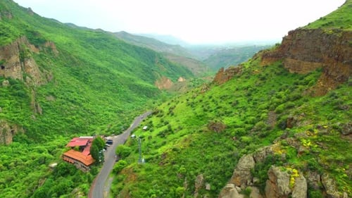 Drone view from above on rural road, mountains, forest. Beautiful landscape