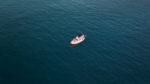 Aerial Drone Tracking Top Down Video of Yacht Cruising in Deep Blue Open Ocean Sea