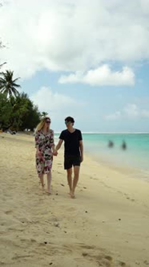 Joven pareja romántica que explora las playas tropicales de la isla de Aitutaki en una aventura de luna de miel