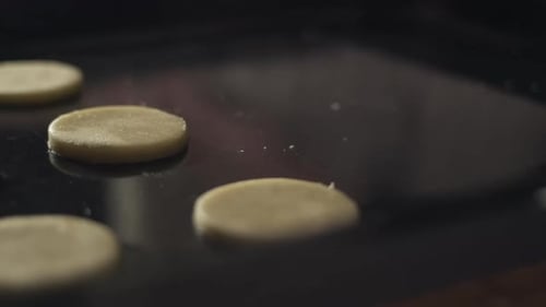 Placing circles of linzer cookie dough on baking sheet, close-up