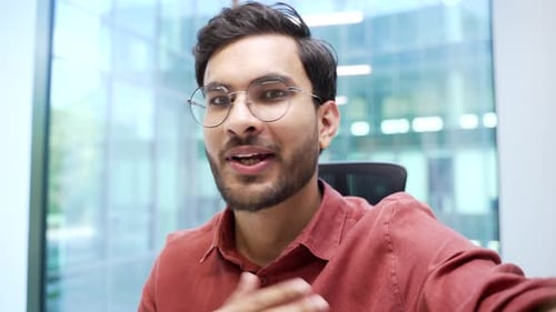 Young Man Talking Directly to Camera in Office