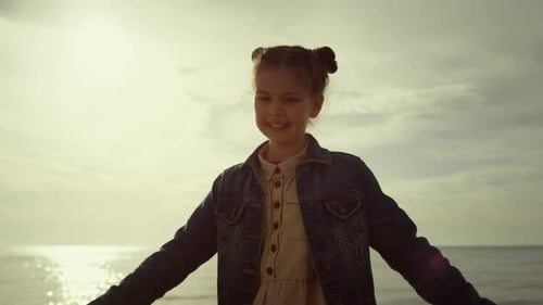 Adorable Girl Enjoying Childhood on Sea Beach Vacation. Kid Dancing on Nature