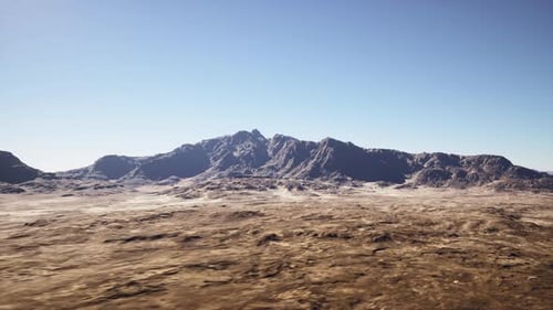 Expansive Barren Terrain Under Clear Cloudless Sky with Distant Ridge