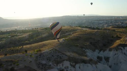Hot air balloons over Cappadocia desert landscape at sunrise