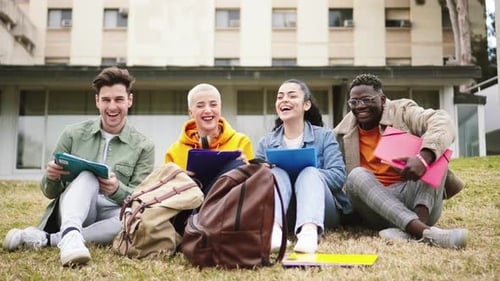 Four Students Sit and Smile on College Campus