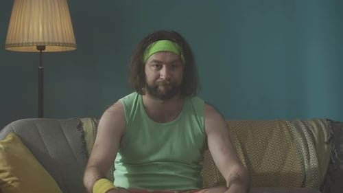 Man in Tank Top Exercises on Couch Indoors