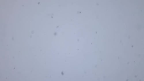 Snow falling out of the sky in slow motion.