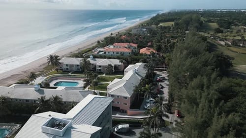 Drohnen-Luftaufnahme von Hotel und Villa im Strandresort mit Meereswellen schaut rein