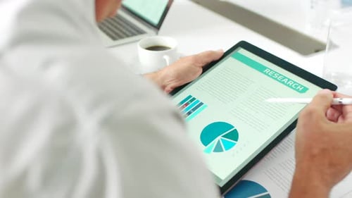 Businessman Reviews Research Data on Tablet at Meeting
