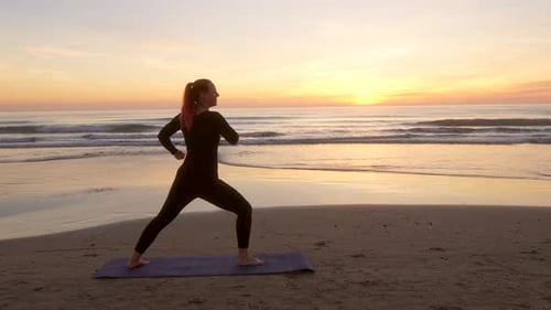 Frau auf einer Matte posiert bei Sonnenaufgang mit zwei Kriegern am Strand