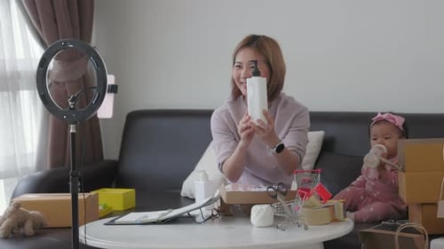 Woman Records Video Blog with Baby Beside Her