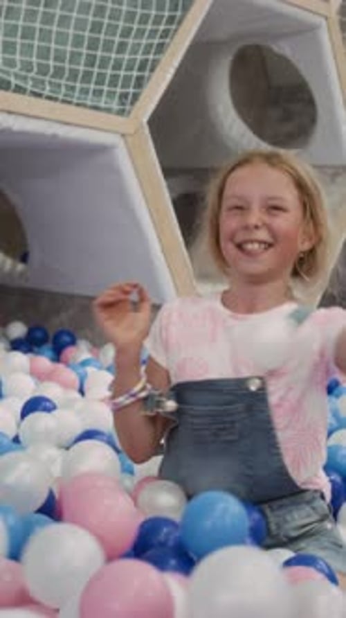 Vertical d'enfants de la génération Alpha jouant dans une piscine à balles