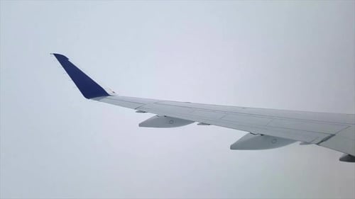 Asa de avião voando através de neblina e nuvens