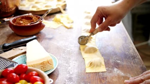 Cutting Homemade Ravioli Pasta Dough on Wooden Table