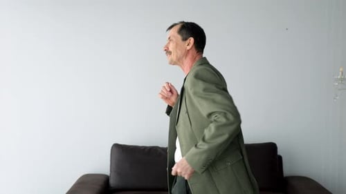 Man Energetically Dances Near Window Moving Arms and Body