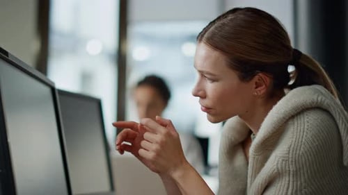 Un
administrador de TI preocupado analiza de cerca el Código del Software. Mujer agotada frotándose la cabeza experimentando