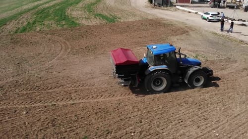 Tractor Driving Through Field on Sunny Day