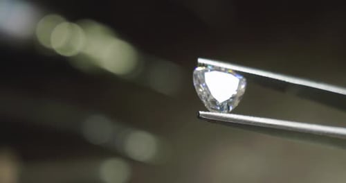 Close up of a goldsmith looking and showing a precious diamond. Concept: Gold, silver, jewelry