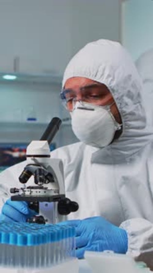 Scientist Looks Through Microscope in Medical Lab