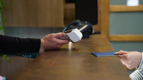 Mujer pagando con tarjeta de crédito en la recepción del hotel