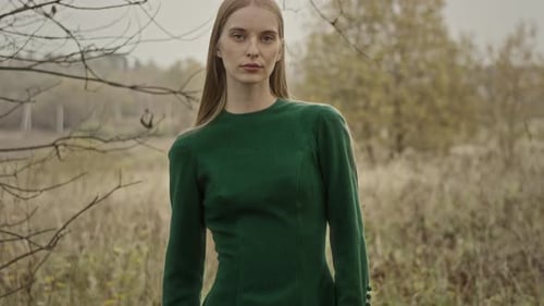 Model posing wearing green dress in autumn nature