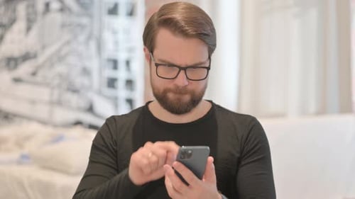 Man with Glasses Using Smartphone