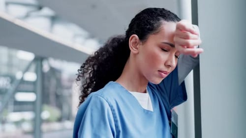 Woman in Scrubs Looking Tired in Hospital