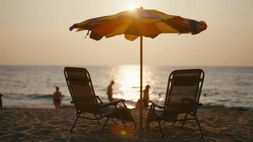Sonnenliegen am Sandstrand unter Sonnenschirm Zwei Liegestühle an der Küste am Strand in der Nähe des azurblauen Meeres