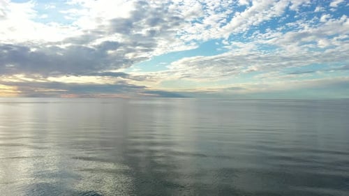 LUFTBILD: Während der Goldenen Stunde sehr langsam über dem Meer fliegen, mit majestätischem Horizont und blauen Farben im
