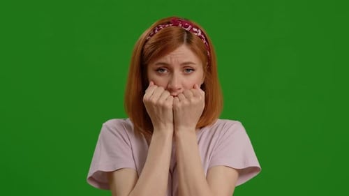 Frightened woman dressed light pink t-shirt express feel fear or anxiety Isolated on Green Screen Ba
